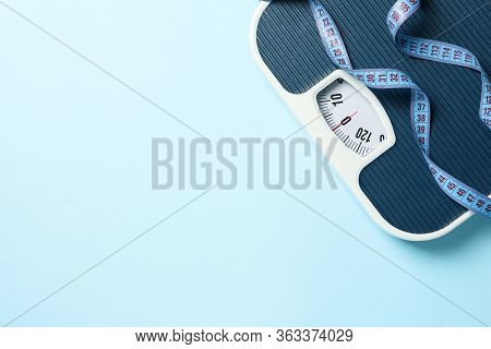 Scales And Measuring Tape On Blue Background. Weight Loss Concept