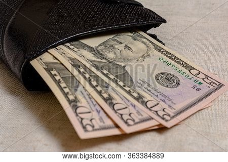 Black Wallet With Dollars 50 On A Gray Background.