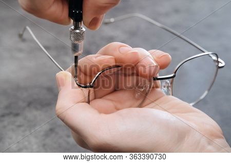 Closeup Of Optician Master Making New Eyeglasses In Optics Using Special Professional Tools. Repairi