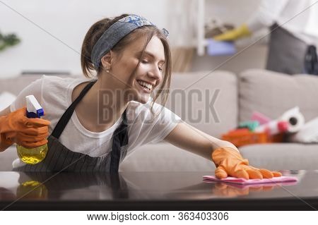 Happy Young Housewife Doing Spring-cleaning At Home, Wiping Dust From Table, Washing Surface With Ra