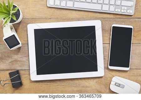 Tablet Smartphone Keyboard Mouse Plant Copy Space On Wood Table Background.