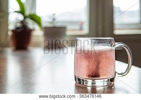 Sparkling Tablet Throw Into A Glass Transparent Glass, The Glass Is On A Table, A Pill For Cold Of C