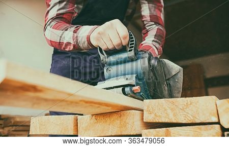 The carpenter process the wood by the belt sander