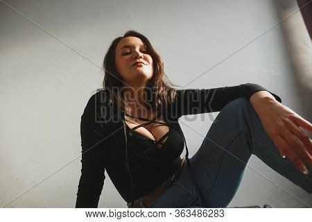 The Look From Below The Young Woman Sits On The Floor Of The Room And Provocative Looks Into The Cam