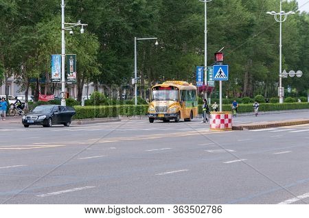 China, Heihe, July 2019: Yellow School Bus On Heihe City Road In Summer