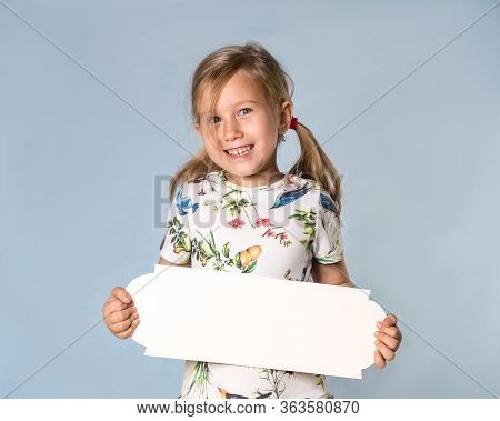 A Little Beautiful Girl With A Tableau For Text. The Concept Of An Ad And A Holiday.