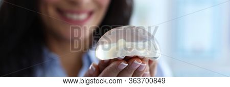 Focus On Breast Silicone Implants In Female Hands. Happy Cheerful Brunette Looking At Transparent Br
