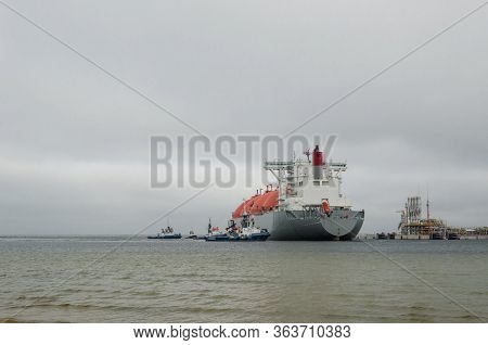 Lng Terminal And Gas Tanker - A Large Ship Maneuvers Into The Unloading Quay