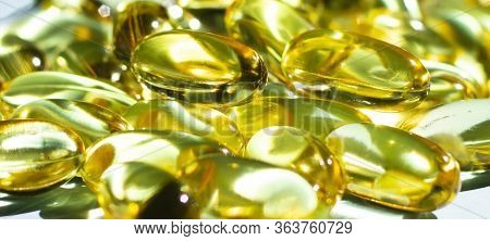 Fish Oil Supplement Capsules Isolated On Blue Background