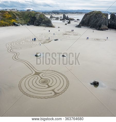 Bandon By The Sea, Oregon / Usa - March 08 2020: Team Of Circles In The Sand Drawing A Walkable Laby
