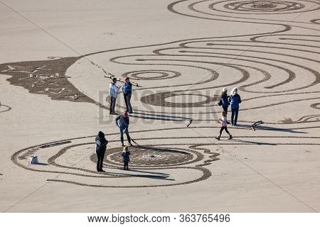 Bandon By The Sea, Oregon / Usa - February 20 2020: The Team Of Circles In The Sand Drawing A Walkab