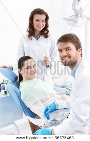 Dentysta, asystent i pacjenta są gotowe do leczenia ubytków zębów