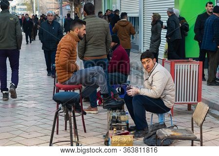 Dogubayazit, Turkey - December 10, 2018: Shoe Cleaner With A Client Working On The Streets Of Doguba