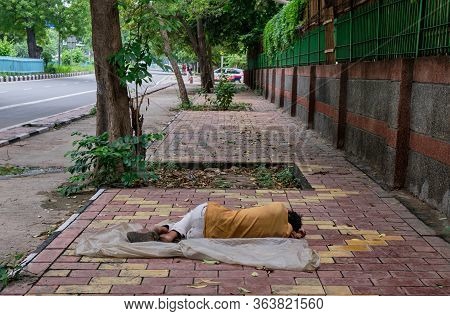 Poor Homeless Man Sleeping On Sidewalk In New Delhi, India