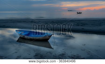 Dinghy Sitting In Tidal Pool At Beach At Low Tide During Sunset In Pythiu On The Gulf Of Thailand