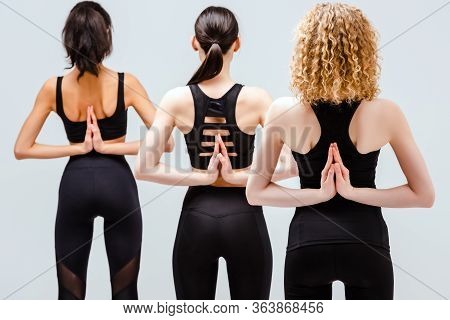 Back View Of Multicultural Women In Reverse Prayer Pose Isolated On White