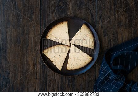 Spicy Circassian Triangle Smoked Cheese Slices On Dark Wooden Plate With Spices.