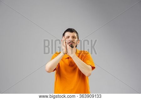 Young Caucasian Man Suffers From Teethache, Feels Sick, Ill And Weakness Isolted On Gray Studio Back