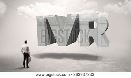 Rear view of a businessman standing in front of IVR abbreviation, modern technology concept