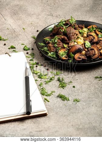 Homemade Beef Stew With Mushrooms And A Side Dish Of Lentils On A Black Plate And A Blank Notebook F