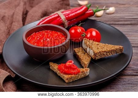 Ajvar Or Pindjur Red Vegetable Spread Or Pepper Paprika And Tomato Mousse In A Clay Bowl In A Black 
