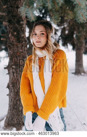 Teen Blonde In A Yellow Sweater Outside In Winter. A Teenage Girl On A Walk In Winter Clothes In A S
