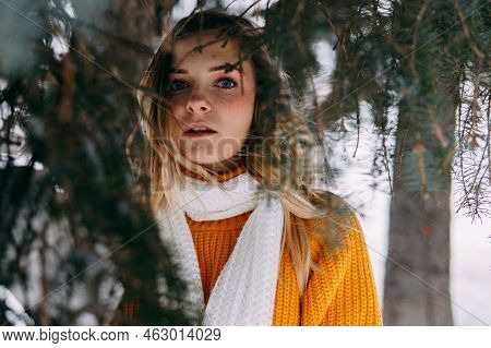 Teen Blonde In A Yellow Sweater Outside In Winter. A Teenage Girl On A Walk In Winter Clothes In A S