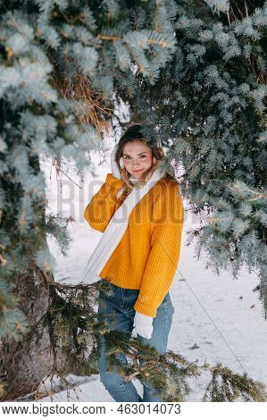 Teen Blonde In A Yellow Sweater Outside In Winter. A Teenage Girl On A Walk In Winter Clothes In A S