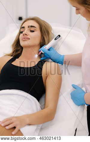 Plasma Pen Reducing Neoplasm Around Neck On Young Woman. Woman At Cosmetology Clinic Taking A Beauty