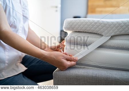 Mattress Topper Being Laid On Top Of The Bed
