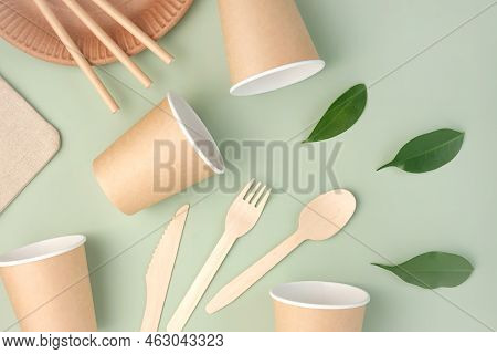 Eco - Friendly Tableware On Green Background. Top View. Plastic Free Set Of Brown Paper Utensil. Str