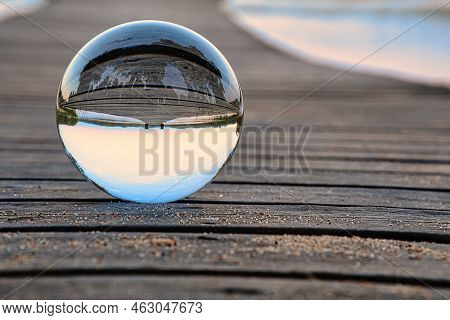 Glass Ball On A Wooden Pier At A Swedish Lake At Evening Hour. Nature Shot From Scandinavia