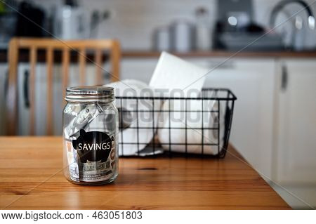 Frugal Living, Save Money, Live Cheap Concept With Toilet Paper Basket And Saving Money Jar On Kitch
