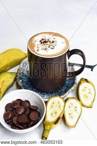 Banana Chocoalte Latte With Fresh Banana And Chocolate Drops On White Table