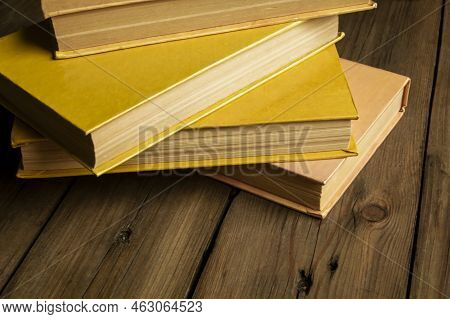 Yellow Books Lie On A Wooden Table. Photo Taken At An Angle. Shifted Horizon - Books On The Table. B