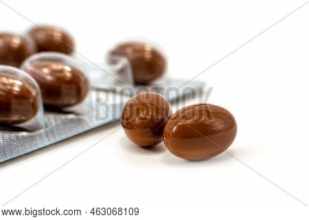 Medical Pills Capsules Of Brown Color On A White Background. Medicinal Preparations Of Plant Origin 