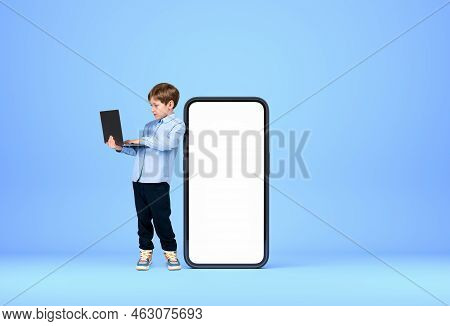 Handsome Young Boy Wearing Formal Wear Is Standing Holding Laptop Near Large Empty White Mockup Smar