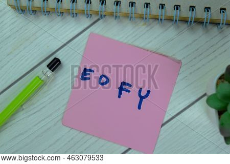 Concept Of Eofy Write On Sticky Notes Isolated On Wooden Table.