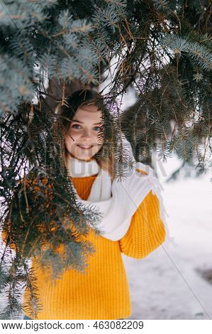 Teen Blonde In A Yellow Sweater Outside In Winter. A Teenage Girl On A Walk In Winter Clothes In A S