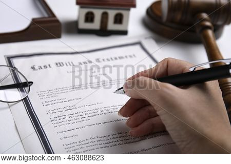 Woman Signing Last Will And Testament At White Table, Closeup