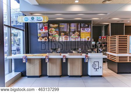 Latvia, Riga, September, 2022 - Mcdonalds Counter With Menu Of Different Fast Food Snacks And Cash D