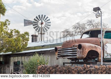Loxton, South Africa - Sep 2, 2022: A Street Scene, With A Corrugated Iron Building, Windmill And A 