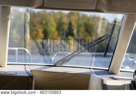 A Deckhouse Of A Boat With A Part Of Windshield And An Autumn Landscape Ahead