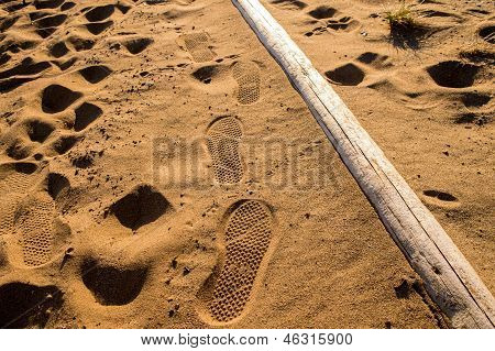 Rastros del paso de zapatos de mar playa de arena-lado
