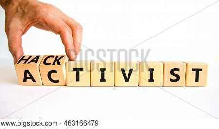 Activist Or Hacktivist Symbol. Businessman Turns Wooden Cubes And Changes The Word Activist To Hackt