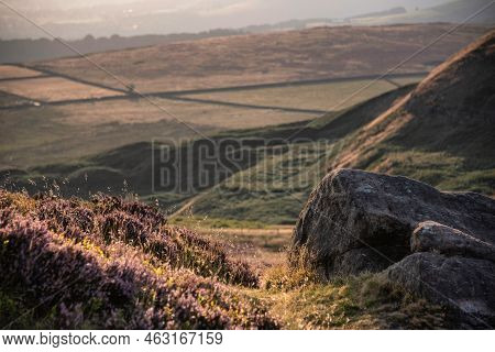 Beautiful Late Summer Landscape Image Looking Through Rocks And Heather Using Selective Focus Techni