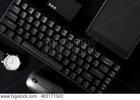 Small Mechanical Computer Keyboard With 68 Keys On A Black Background Next To A Wristwatch, A Comput