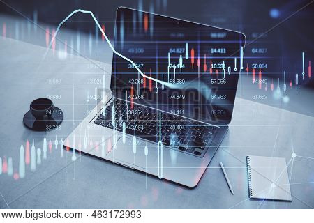 Close Up Of Desktop With Coffee Cup, Notepad And Laptop, Glowing Candlestick Forex Chart And Map Hol