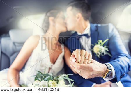 Just Married Couple Kisses In The Car Showing Rings On Fingers Towards The Camera.