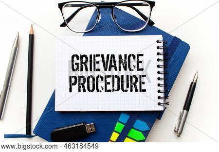 Text Grievance Procedure On Notepad With Office Tools, Pen On Financial Report . Business And Financ